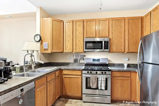 a kitchen with stainless steel appliances granite countertop a stove a sink and a microwave