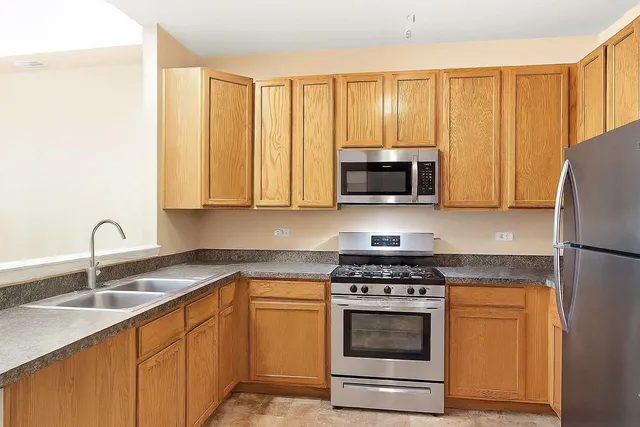 a kitchen with granite countertop a stove a sink and a microwave