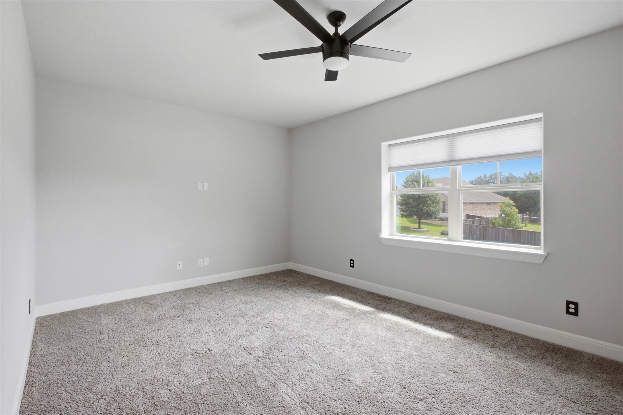 1113 Modoc Way Kyle, TX 78640 - Photo 22 of 34 A well-lit bedroom features plush carpeting and a modern ceiling fan for ultimate comfort.
