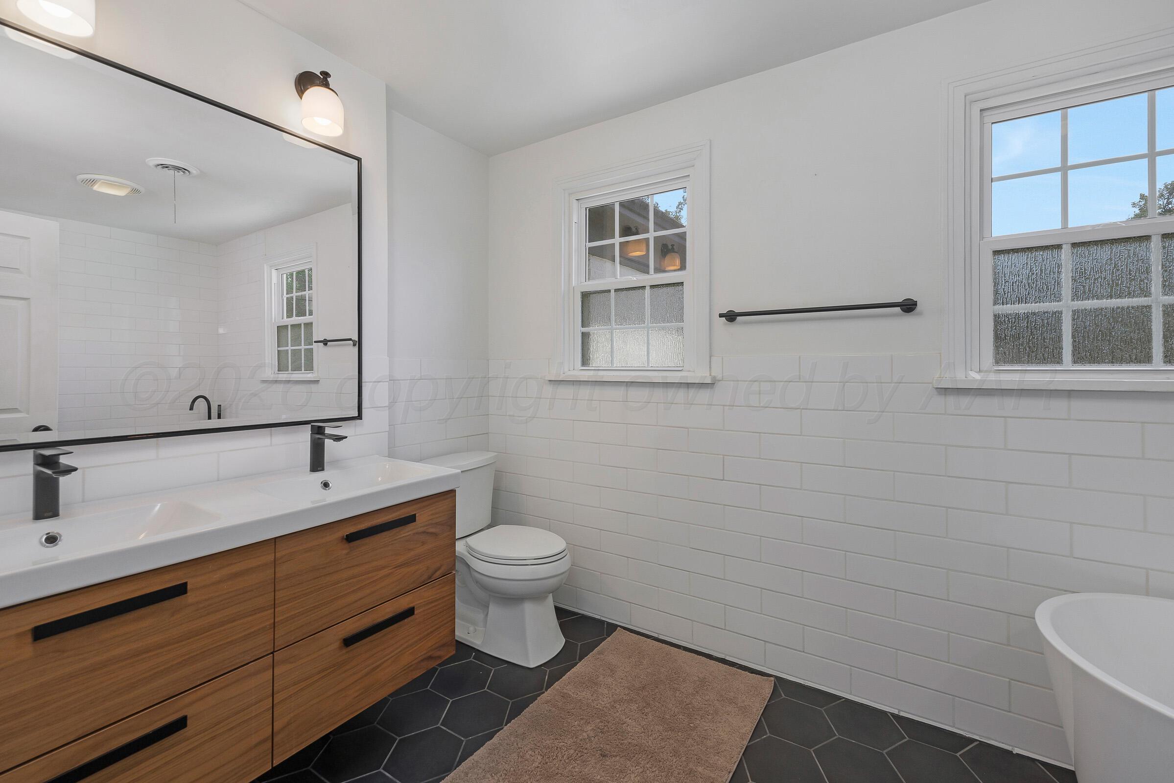 2102 South Hayden Street Amarillo, TX 79109 - Photo 27 of 44 a bathroom with a sink toilet a mirror and vanity