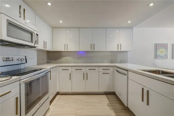 a kitchen with granite countertop cabinets stainless steel appliances and a sink