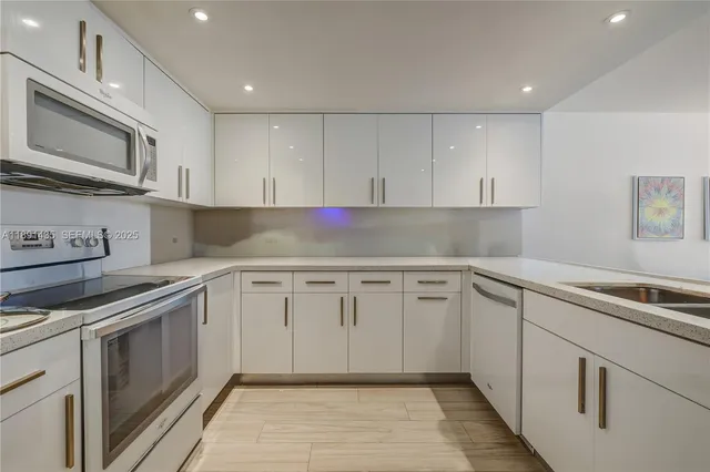 a kitchen with granite countertop cabinets stainless steel appliances and a sink