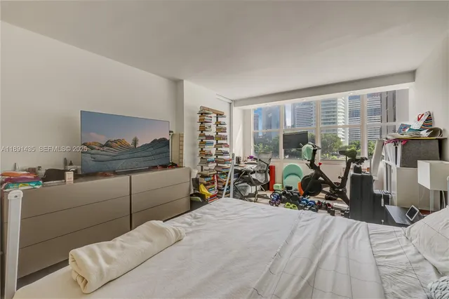 a bedroom with furniture and a large window