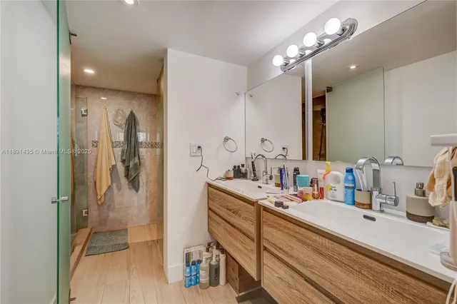 a bathroom with a double vanity sink a mirror and a shower