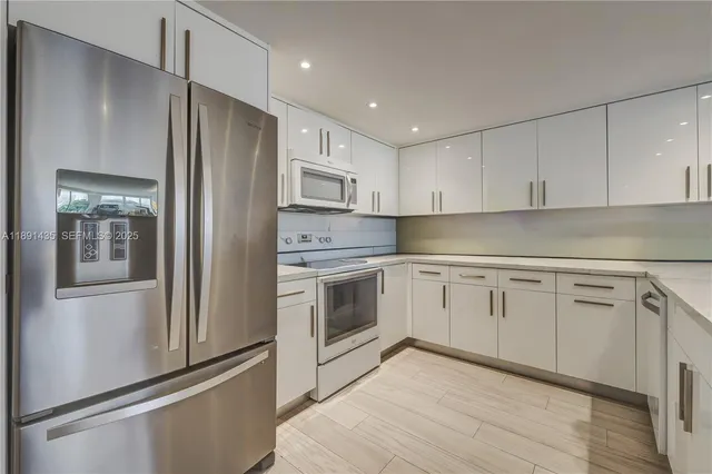 a kitchen with white cabinets and stainless steel appliances