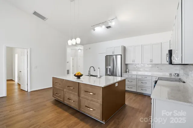 a kitchen with a sink cabinets and wooden floor