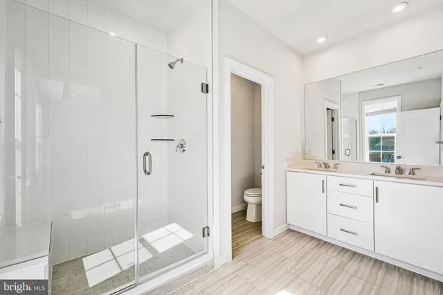a bathroom with a double vanity sink toilet and shower