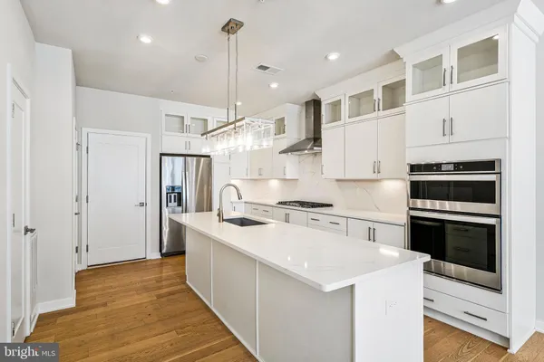 a kitchen with stainless steel appliances kitchen island a refrigerator sink and cabinets