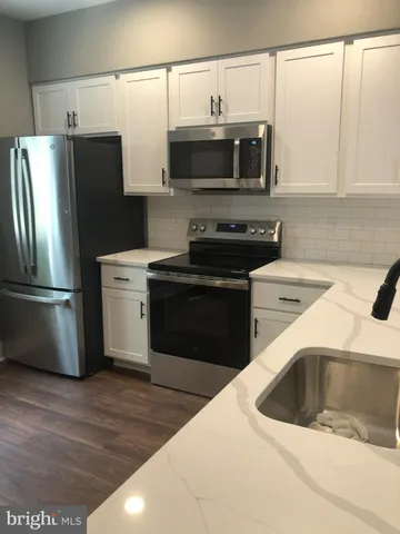 a kitchen with stainless steel appliances a stove a sink and a microwave