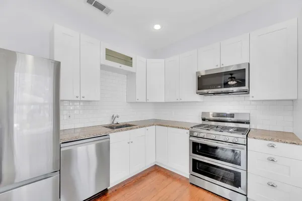 a kitchen with appliances a sink and cabinets
