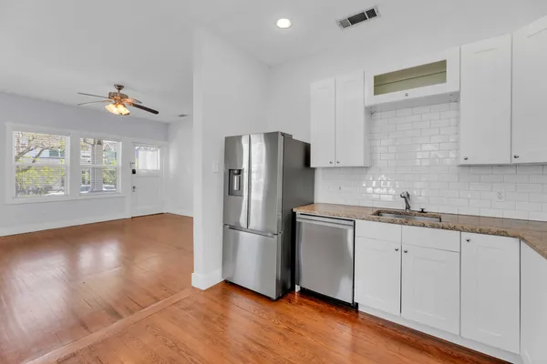 a kitchen with granite countertop a refrigerator and a sink