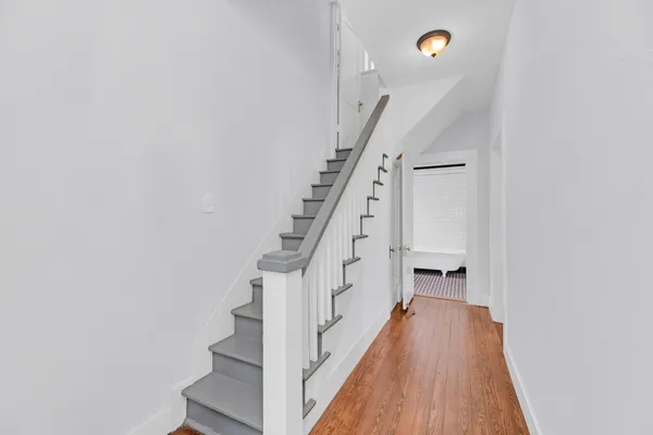 a view of staircase with wooden floor and white walls