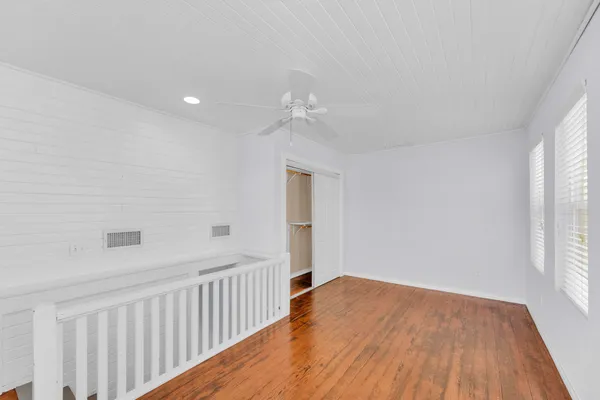 a view of a room with wooden floor and fan