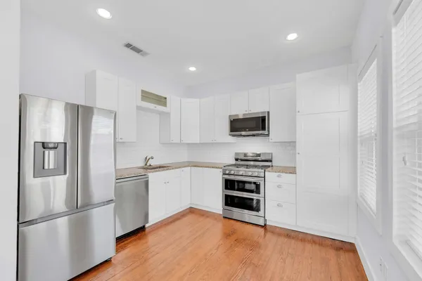 a kitchen with stainless steel appliances granite countertop a refrigerator stove and sink