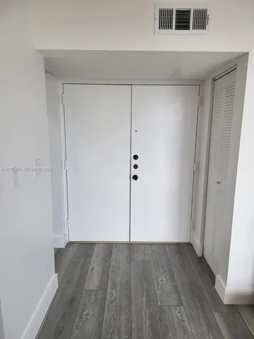 an empty room with wooden floor and cabinet
