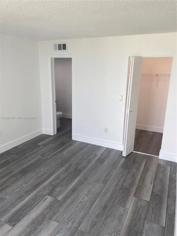 an empty room with wooden floor and closet