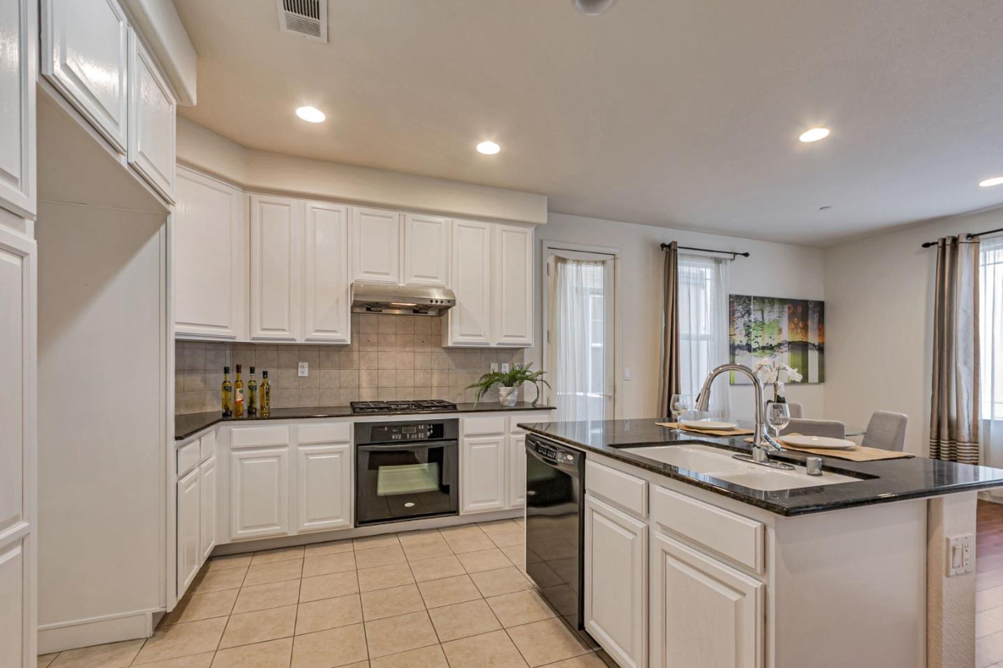 1103 Vida Larga Loop Milpitas, CA 95035 - Photo 12 of 44 a kitchen with stainless steel appliances granite countertop a sink stove and cabinets
