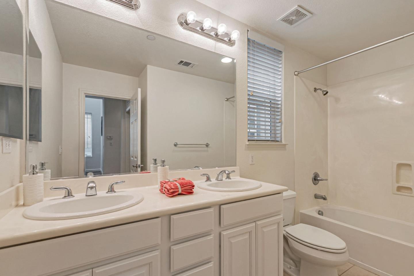 1103 Vida Larga Loop Milpitas, CA 95035 - Photo 30 of 44 a bathroom with a toilet a sink a mirror a shower a vanity and window