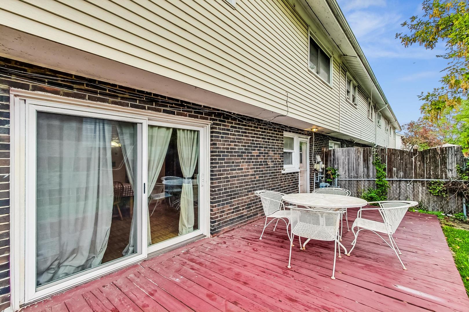 8803 Robin Drive Des Plaines, IL 60016 - Photo 14 of 18 a view of a patio with table and chairs with wooden floor and fence