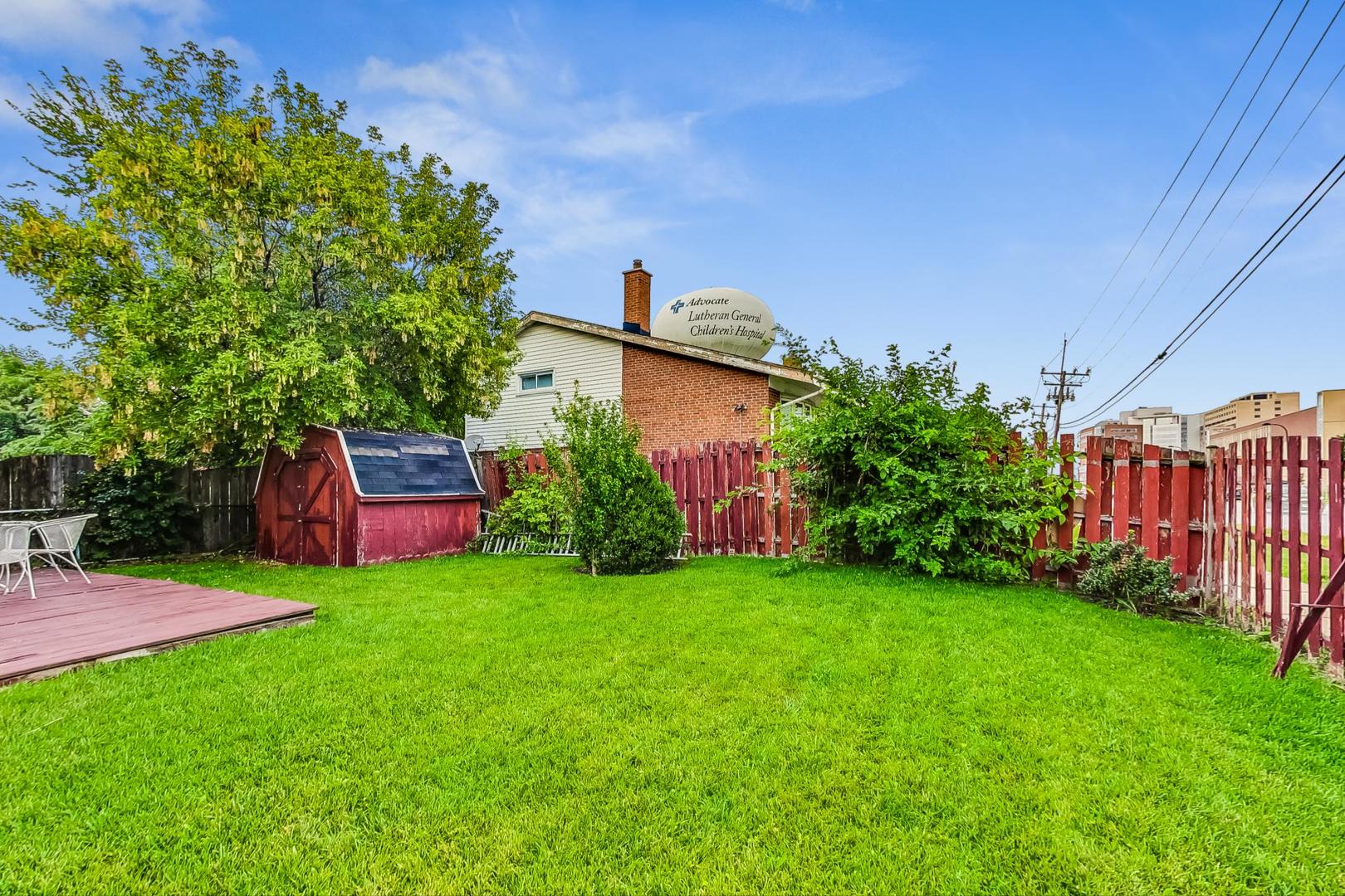 8803 Robin Drive Des Plaines, IL 60016 - Photo 17 of 18 a view of a backyard with potted plants and large tree