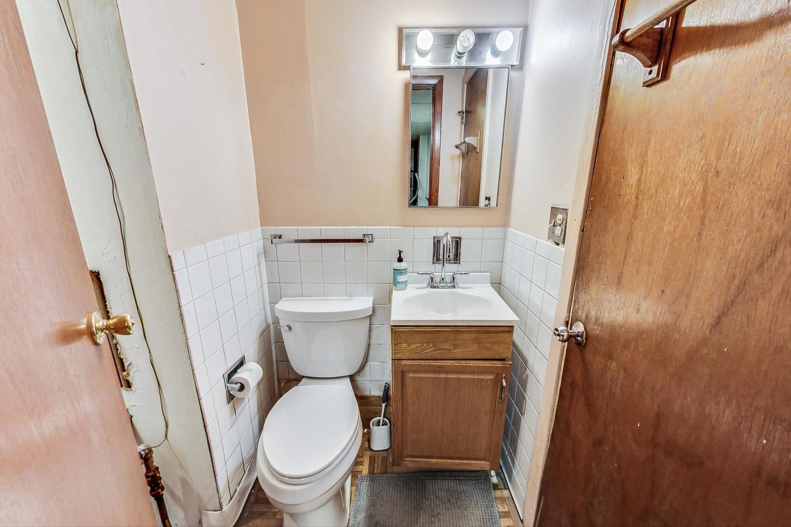 8803 Robin Drive Des Plaines, IL 60016 - Photo 9 of 18 a bathroom with a sink a toilet and a mirror