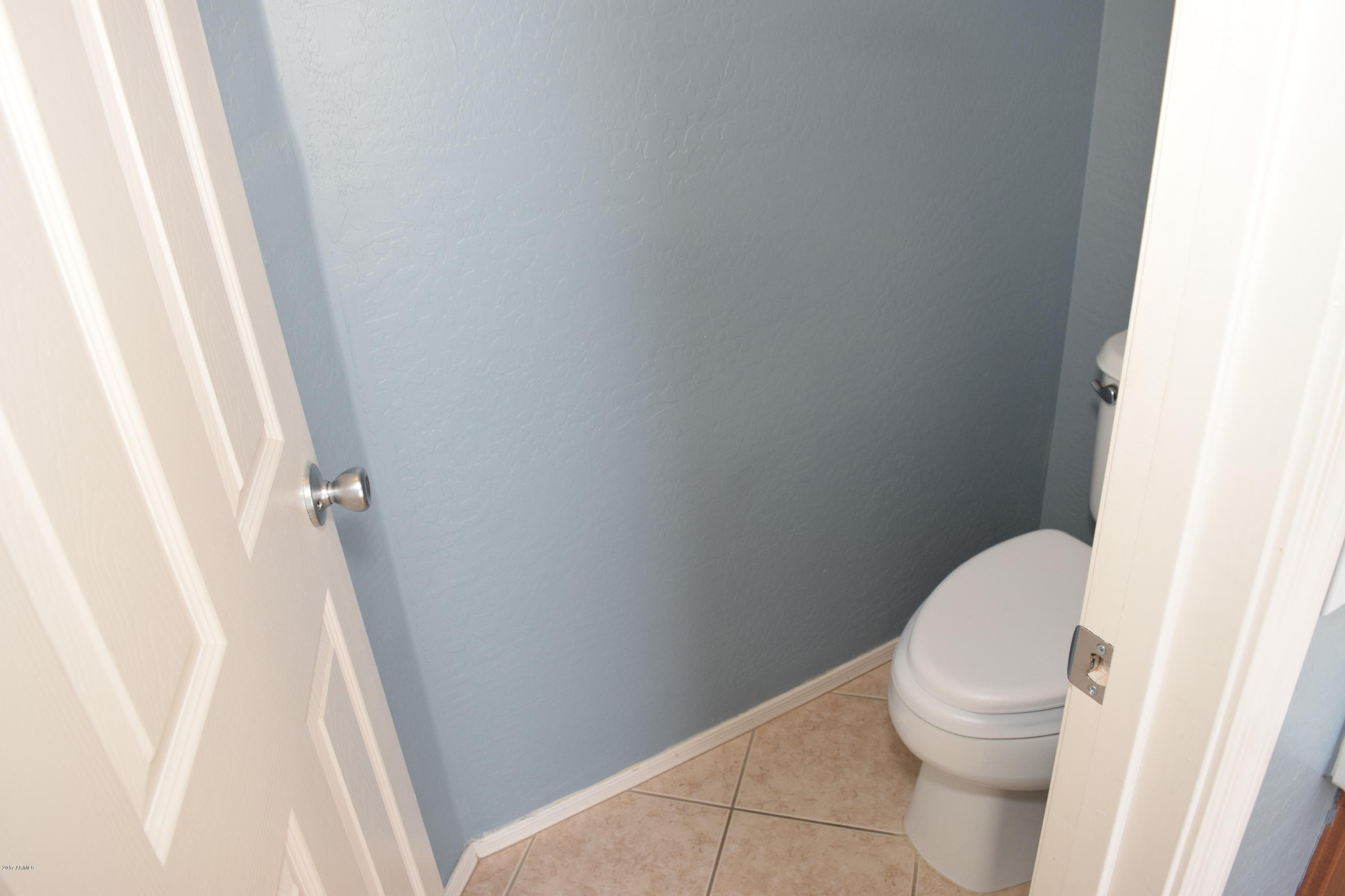 15761 West Calavar Road Surprise, AZ 85379 - Photo 12 of 36 a white toilet sitting next to a wooden floor