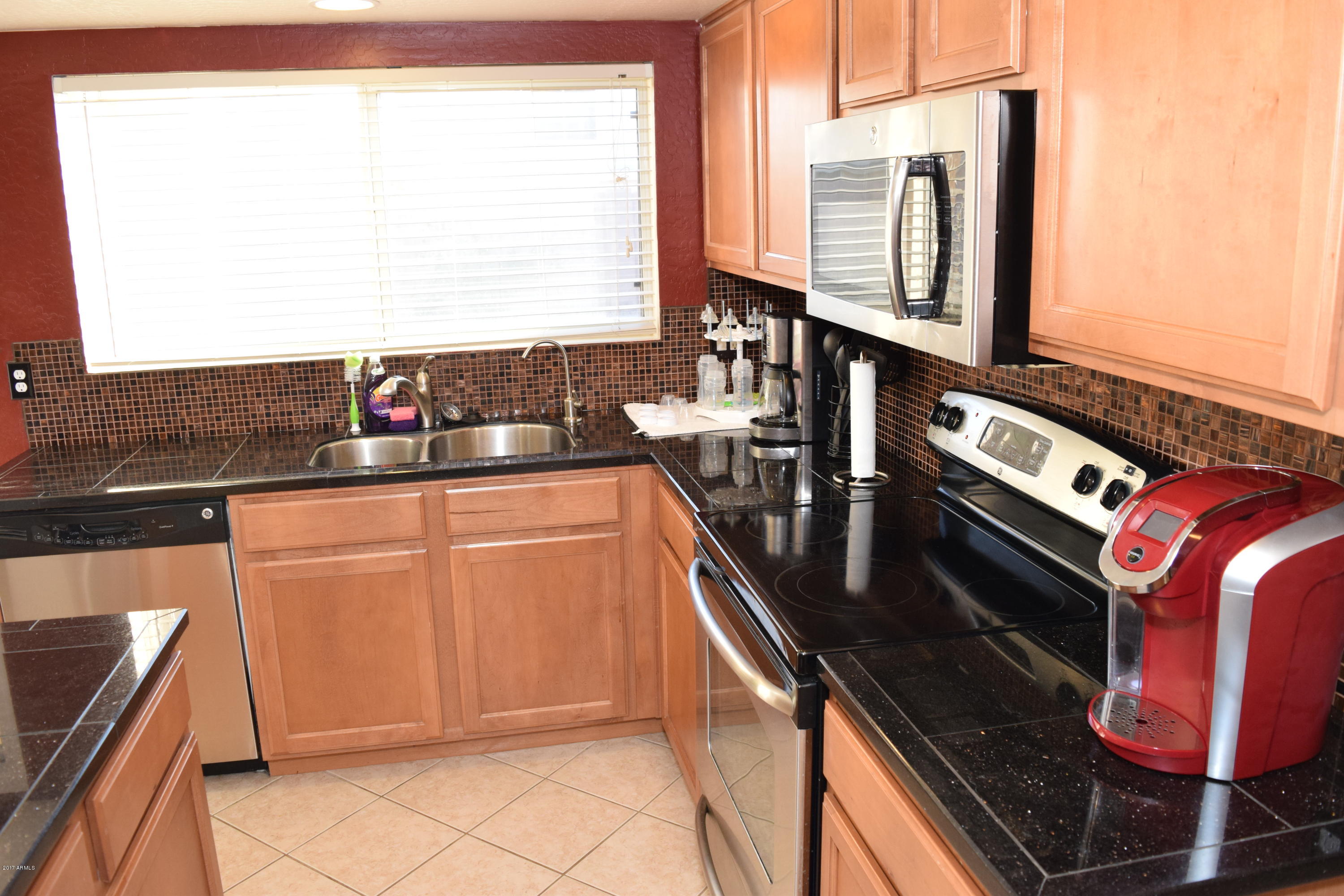 15761 West Calavar Road Surprise, AZ 85379 - Photo 27 of 36 a kitchen with stainless steel appliances granite countertop a sink stove and microwave