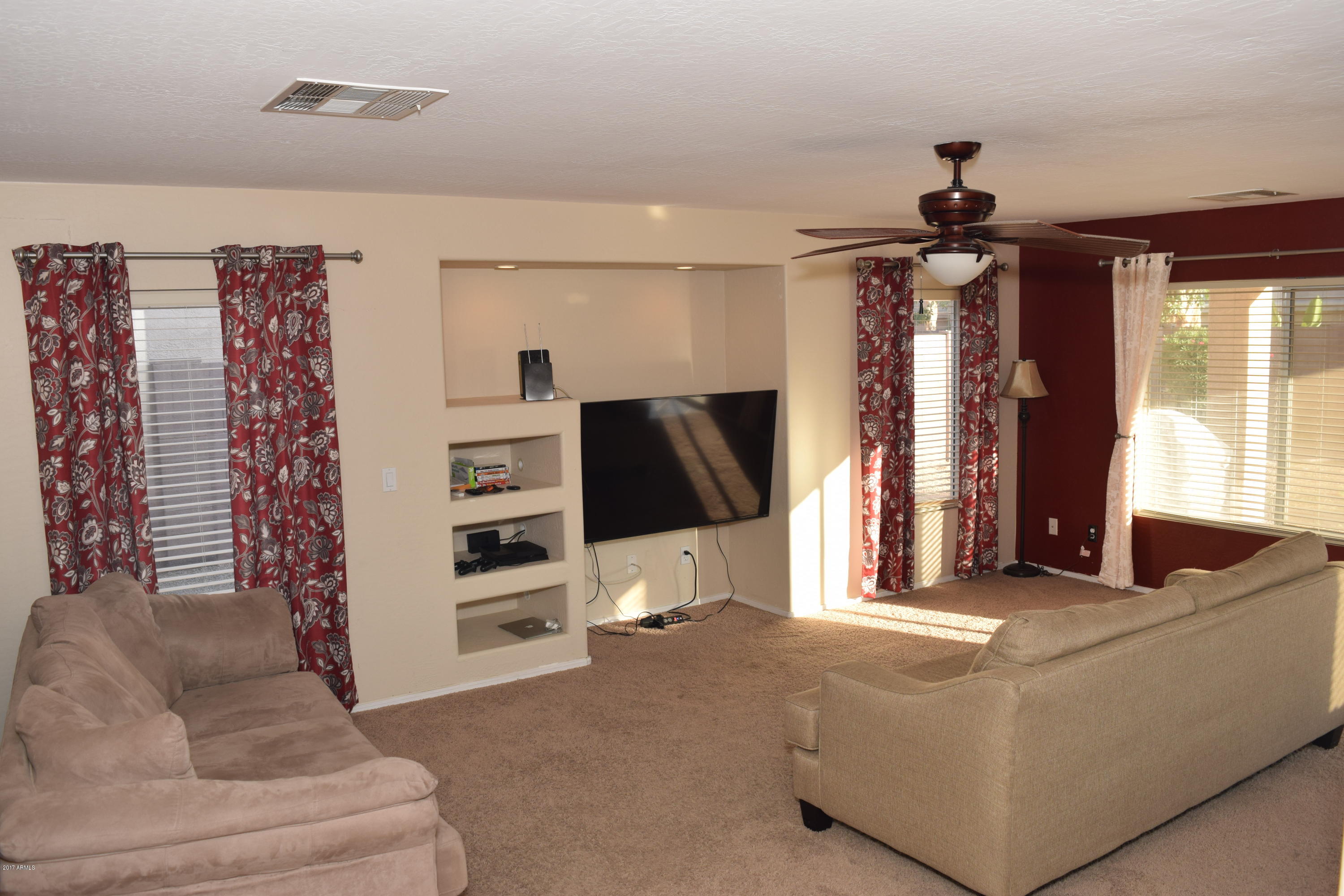 15761 West Calavar Road Surprise, AZ 85379 - Photo 30 of 36 a living room with furniture and a flat screen tv