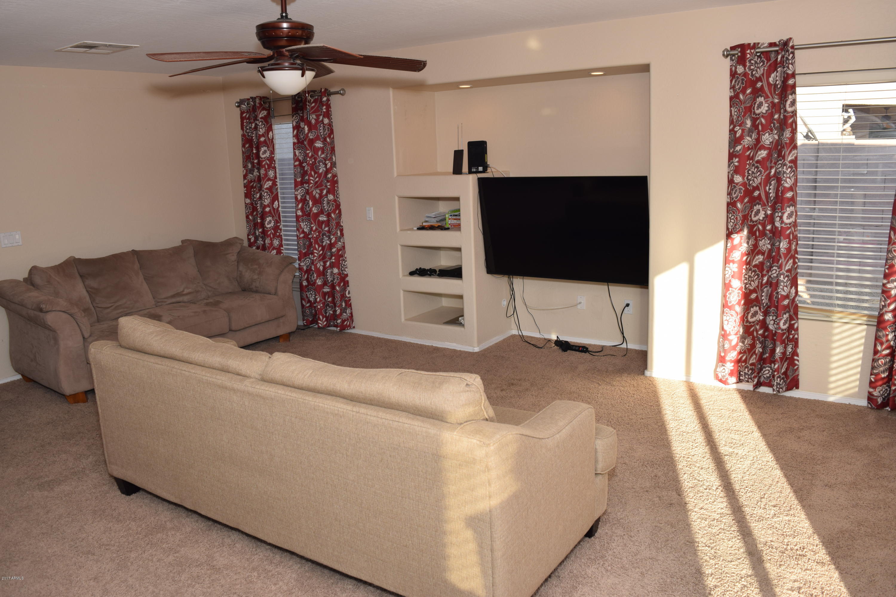 15761 West Calavar Road Surprise, AZ 85379 - Photo 32 of 36 a living room with furniture and a flat screen tv