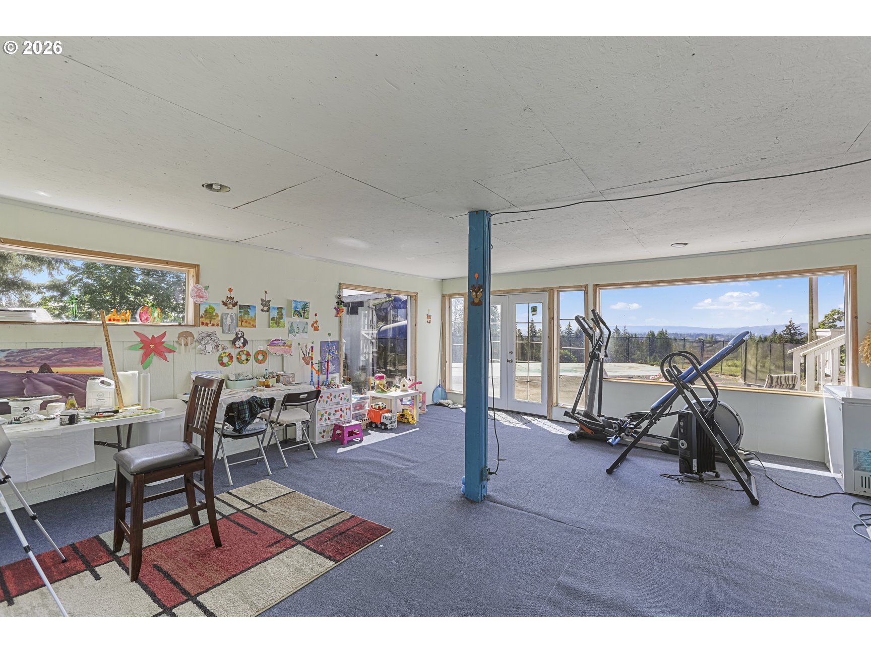33411 Blaha Road Warren, OR 97053 - Photo 32 of 48 a living room with furniture a window and gym equipment