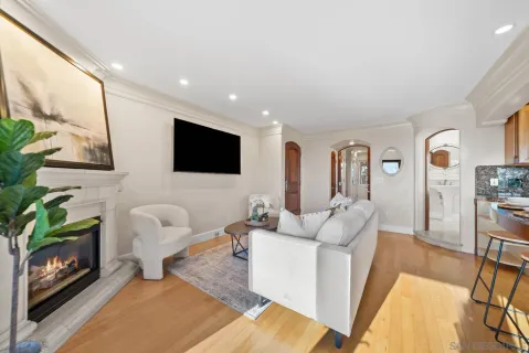 a living room with furniture a flat screen tv and a fireplace