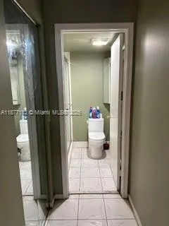 a bathroom with a toilet and a mirror