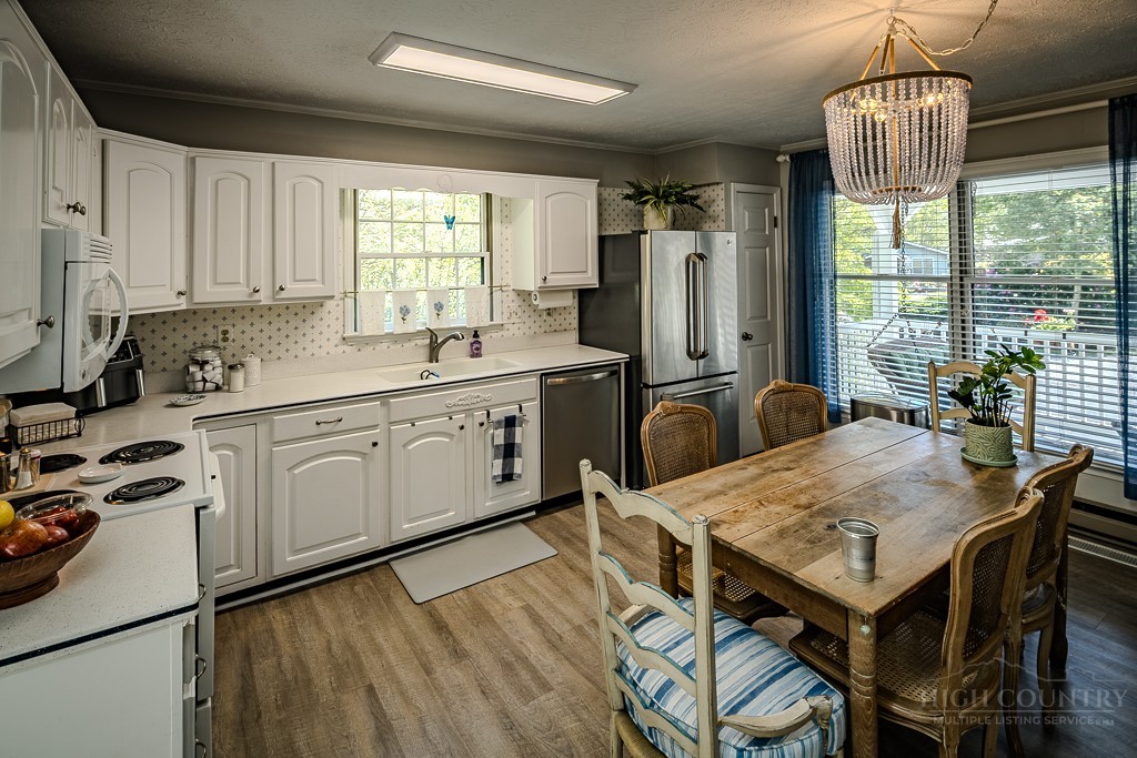 38 Rocky Meadows Road Newland, NC 28657 - Photo 9 of 50 a kitchen with stainless steel appliances granite countertop a table chairs sink refrigerator and microwave
