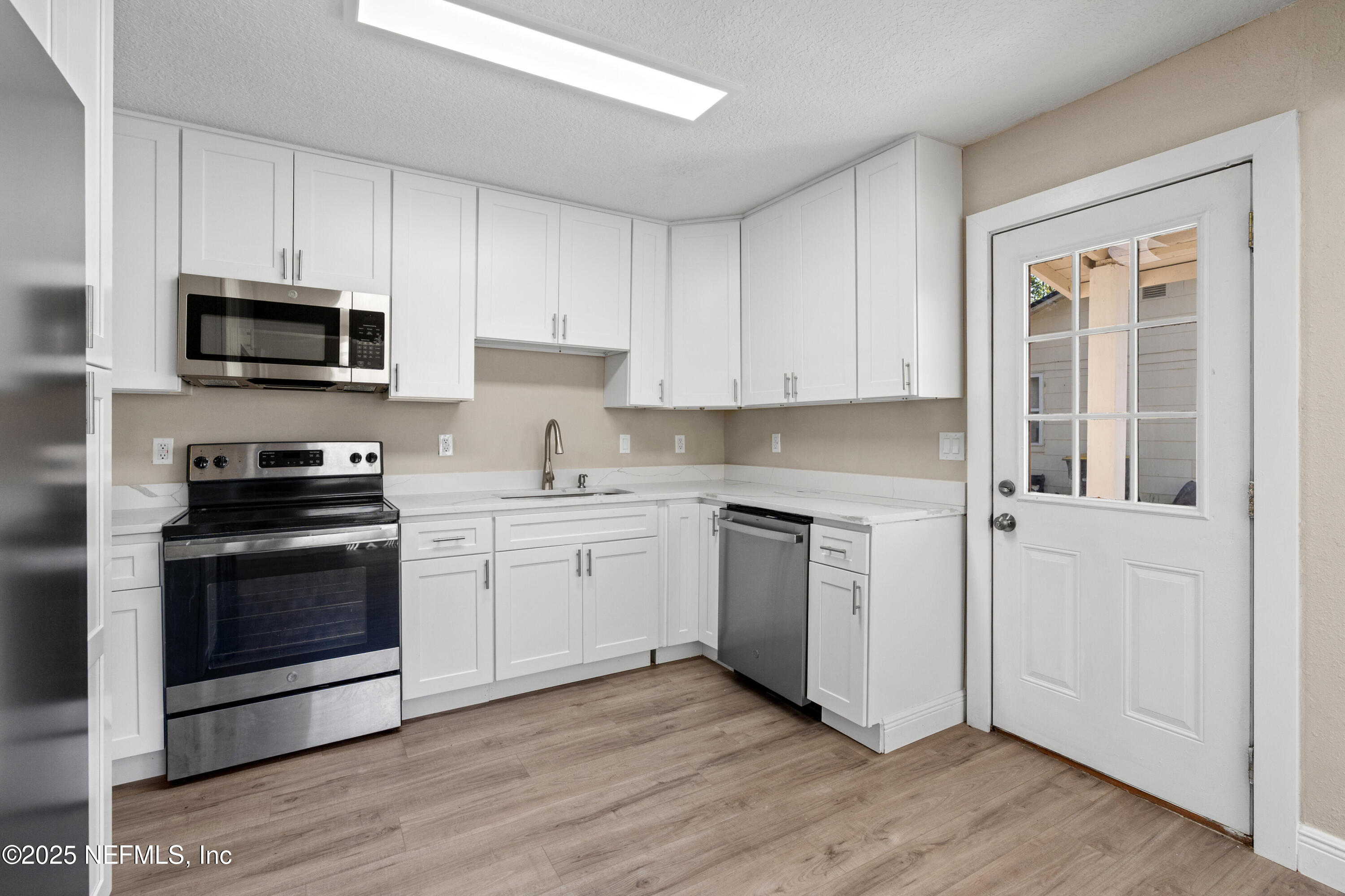 1169 Comanche Street Jacksonville, FL 32205 - Photo 12 of 24 a kitchen with granite countertop white cabinets and stainless steel appliances