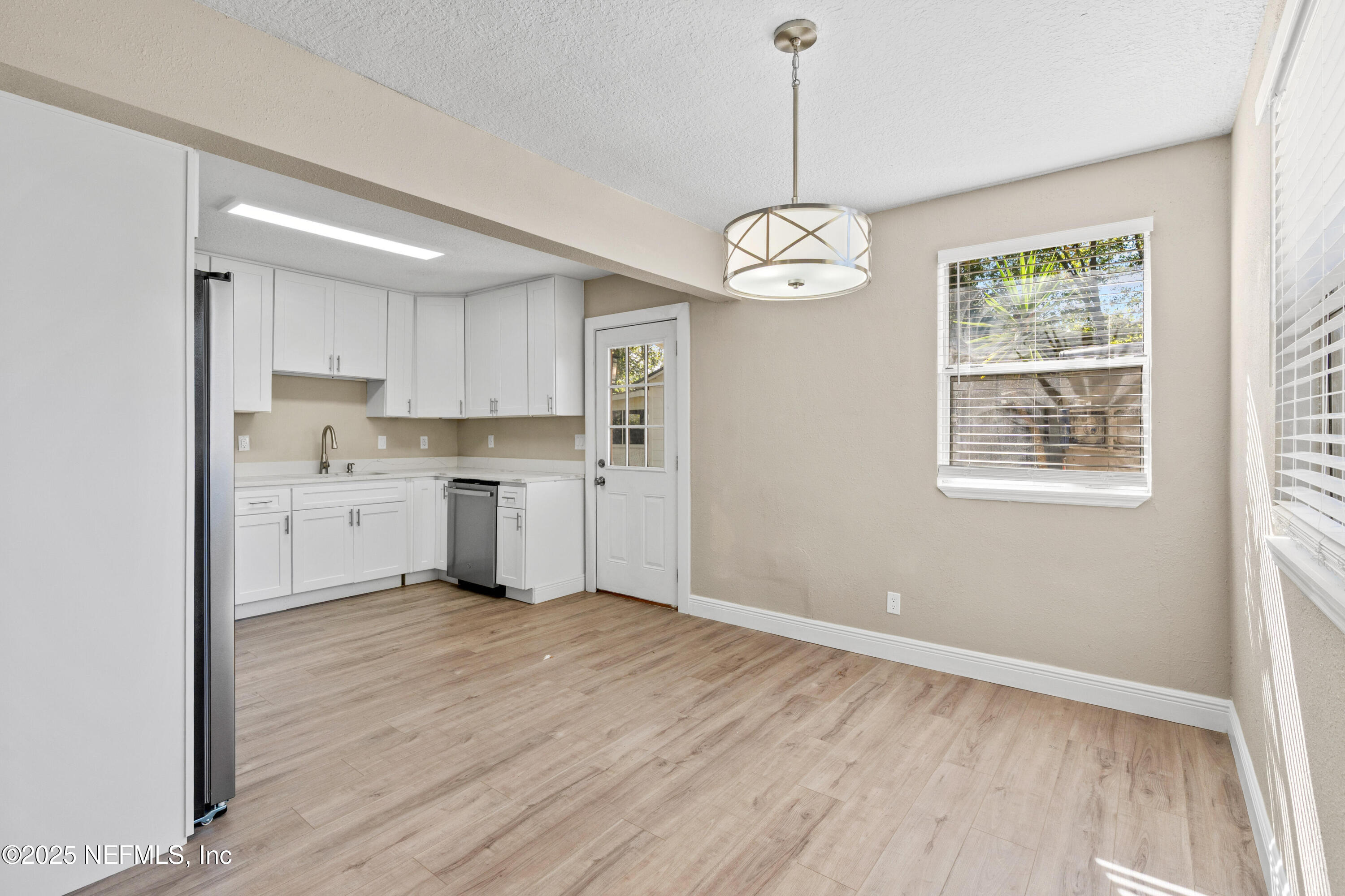1169 Comanche Street Jacksonville, FL 32205 - Photo 5 of 24 a view of a kitchen with a sink dishwasher window and wooden floor