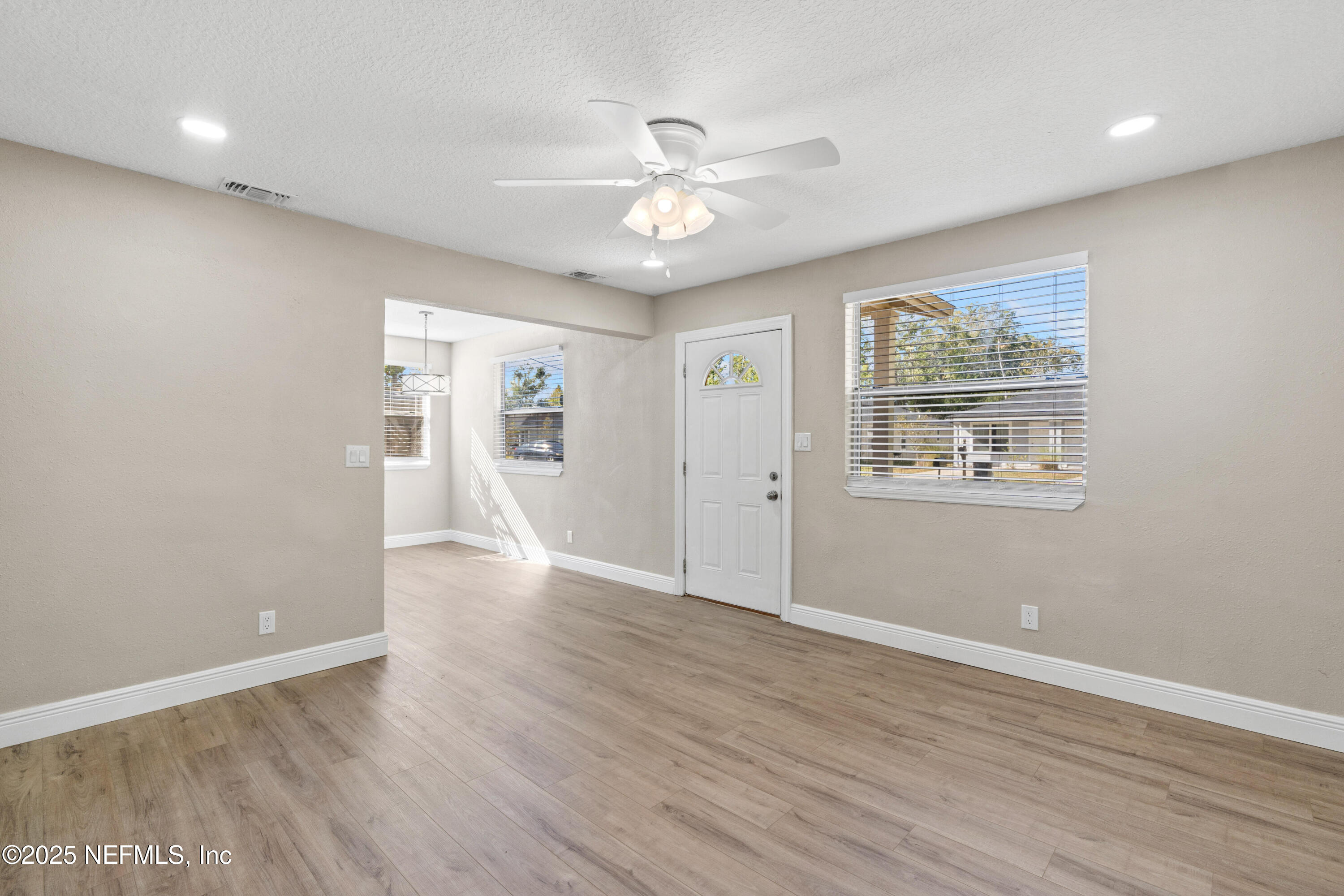 1169 Comanche Street Jacksonville, FL 32205 - Photo 8 of 24 a view of an empty room with wooden floor and a ceiling fan
