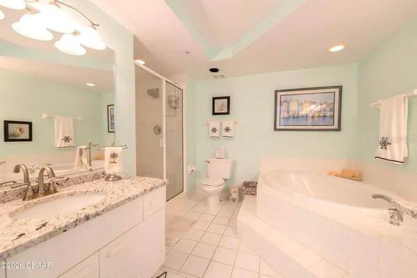 a bathroom with a granite countertop sink mirror and bathtub