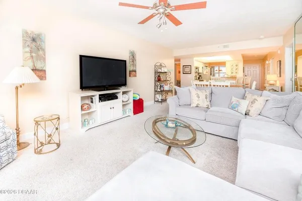 a living room with furniture a flat screen tv and a window