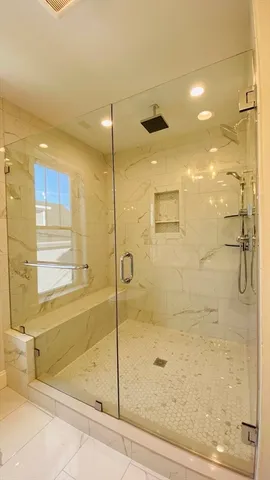 a bathroom with a glass shower door and a shower