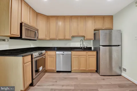 a kitchen with a refrigerator sink and cabinets