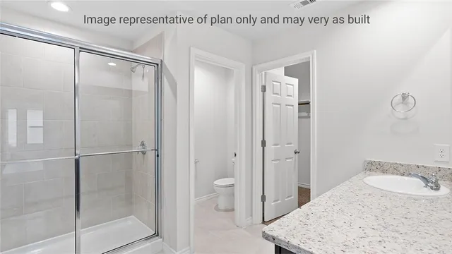 a bathroom with a granite countertop sink a mirror and shower