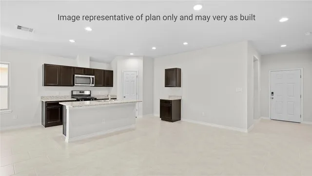 a large white kitchen with stainless steel appliances
