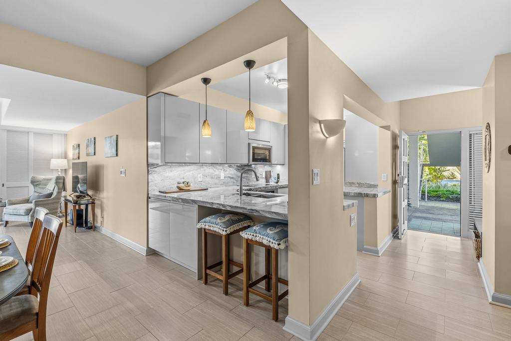 69-1010 Keana Place, Unit B101 Waikoloa, HI 96738 - Photo 2 of 30 a kitchen with stainless steel appliances granite countertop a refrigerator and a stove top oven