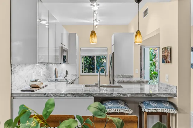 a kitchen with kitchen island granite countertop a stove a sink and a counter space