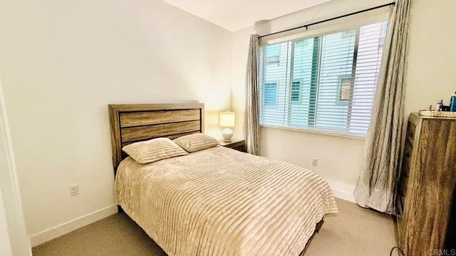 a bedroom with a bed and a refrigerator