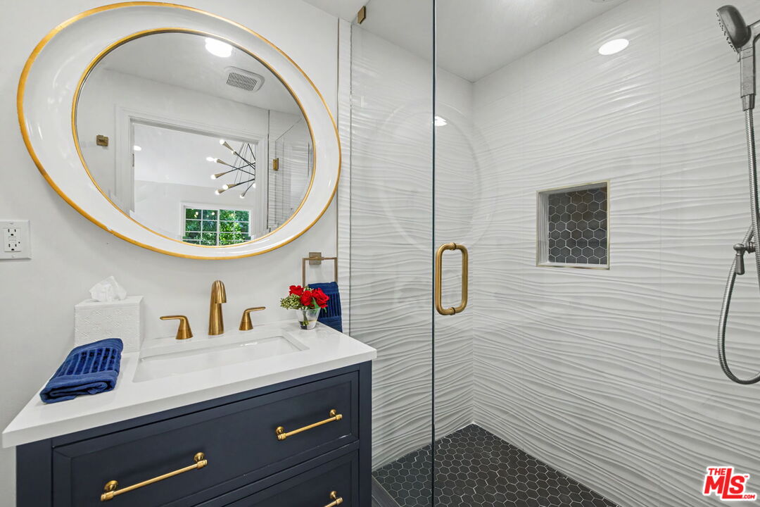204 Foothill Road Beverly Hills, CA 90210 - Photo 36 of 38 a bathroom with a sink a mirror and a shower