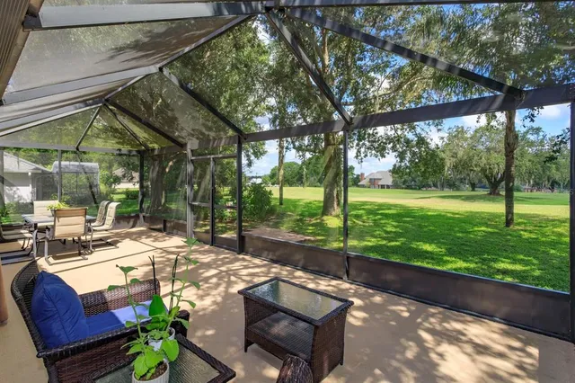 a view of a patio with table and chairs potted plants and large tree