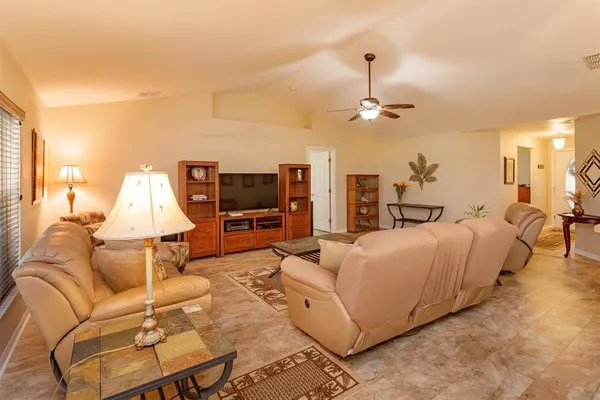 a living room with furniture a flat screen tv and a table