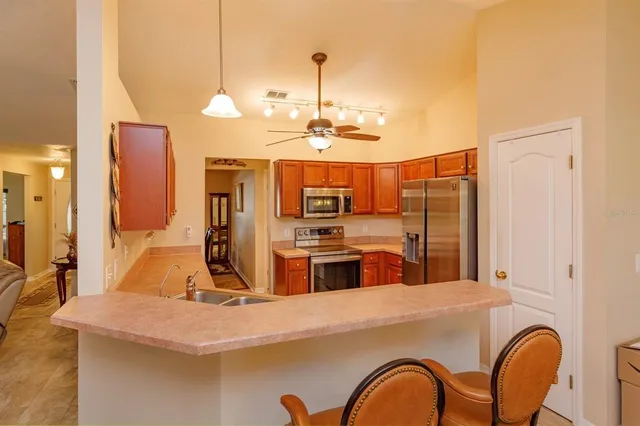 a kitchen with kitchen island a counter top space a sink stainless steel appliances and cabinets