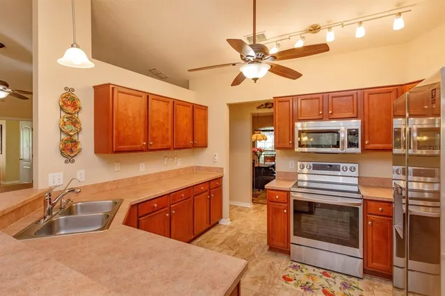a kitchen with stainless steel appliances a stove a sink and a refrigerator